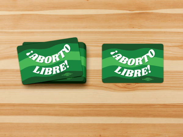 Rectangle sticker with a green color pallet background. White text across the sticker says "¡Aborto Libre!" A union bug sits on the bottom right.