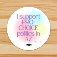 round white sticker with a watercolor background of green, pink and yellow. Text overlays the background ""I Support Pro-Choice Politics in AZ" and a union bug sits at the bottom of the sticker.