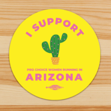 round sticker with yellow background and a saguaro in the center. Pink text along the top of the sticker says "I support" and text across the bottom says in smaller text "pro choice women running in" and in a larger font "Arizona" a union bug sits at the bottom at the sticker under the word "ARizona"